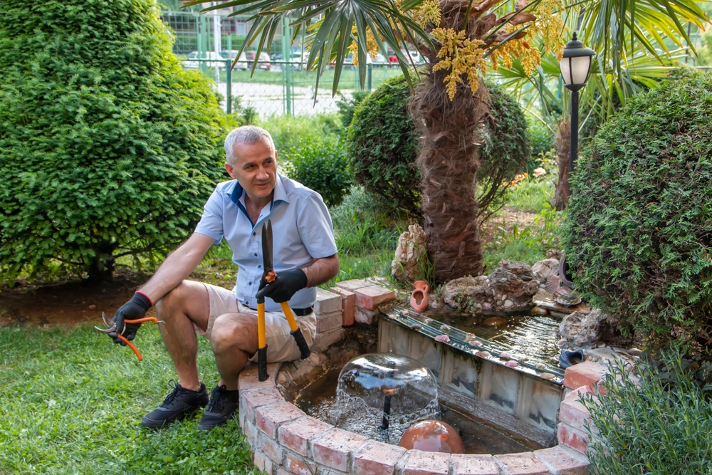 gardener next to small fountain